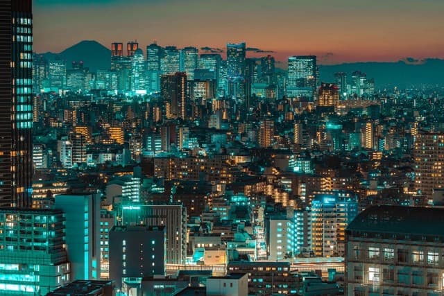 Dusk city skyline with Mount Fuji in the distance